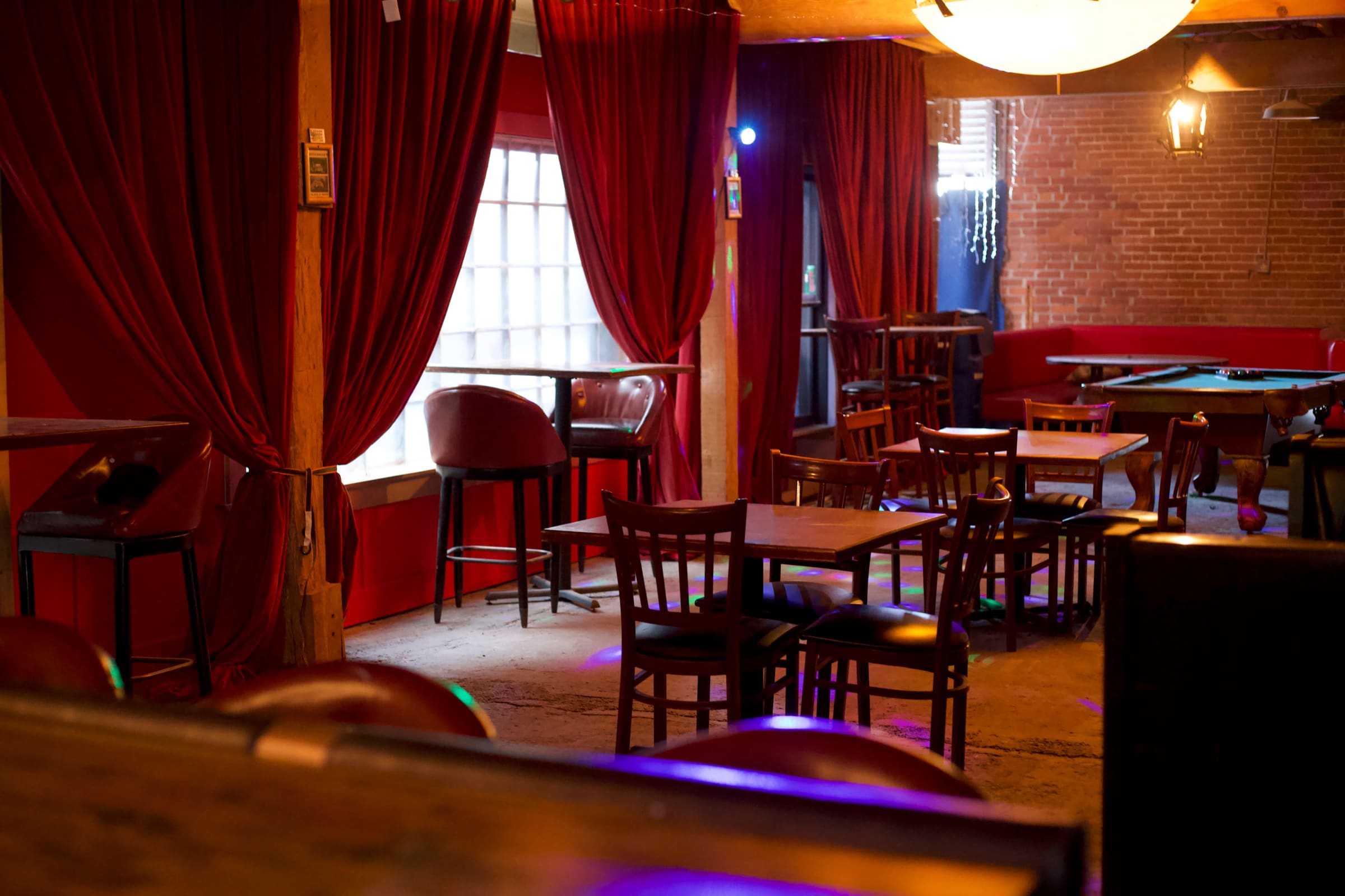 Inside Inclusionary Film Studios, Bar set with red drapes and pool table
