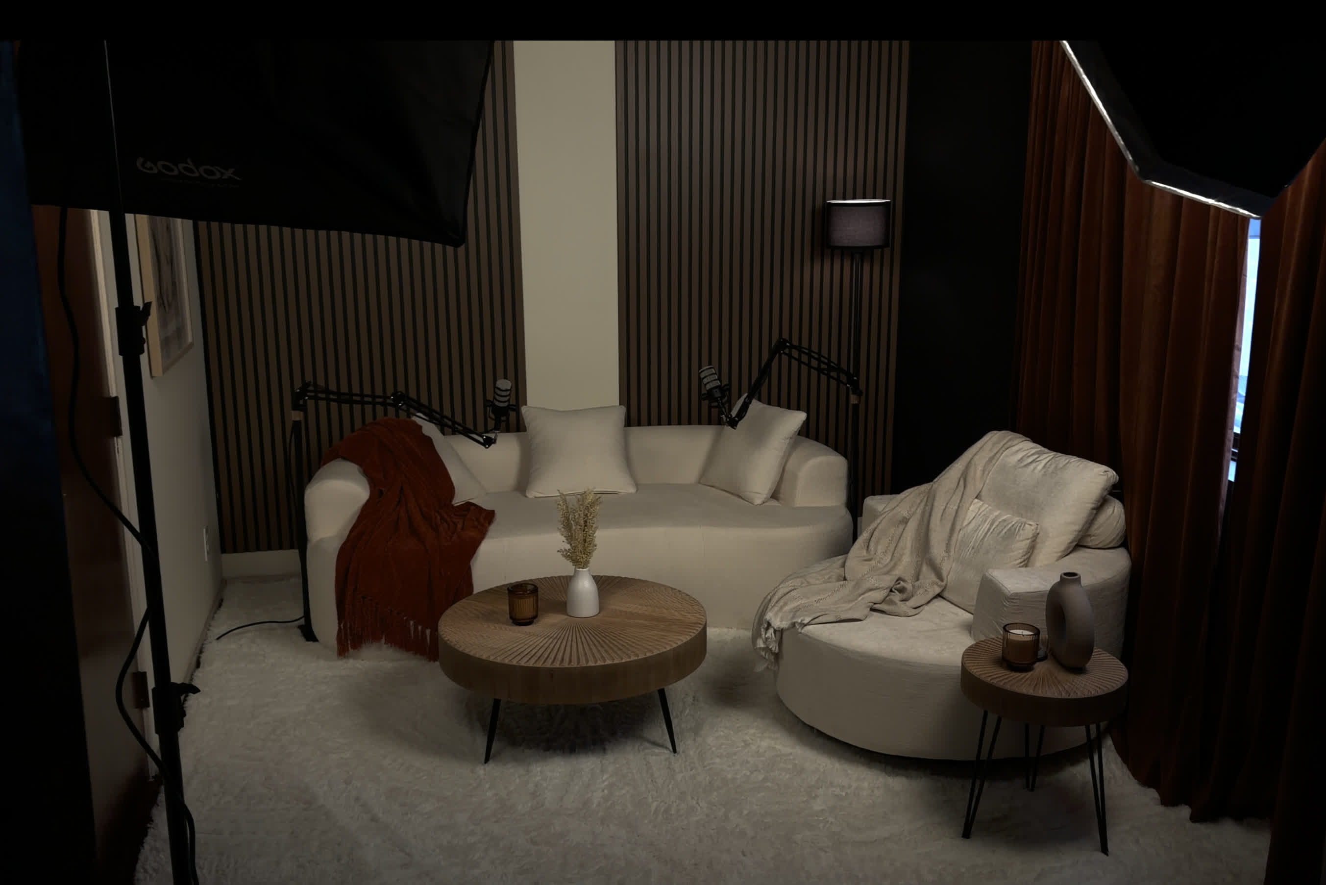 The Podcast Room - intimate two-mic lounge with softboxes, velvet drapes, slatted wood wall
